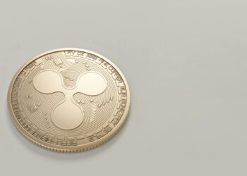 Two hands holding a digital shield with a glowing XRP logo, symbolizing crypto security enhancements.