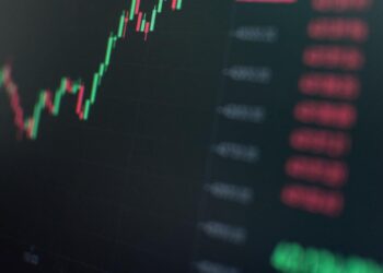 Financial graphs and digital currencies displayed on a screen, representing crypto investment.