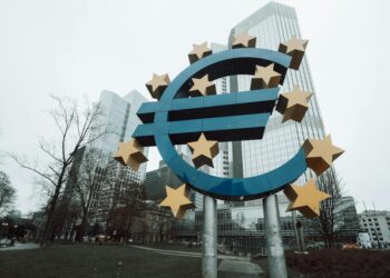 Central bank building with digital currency symbols and financial charts in the foreground.