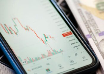 A chart showing a steep decline in RAVE token value amid financial news headlines.