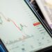 A chart showing a steep decline in RAVE token value amid financial news headlines.