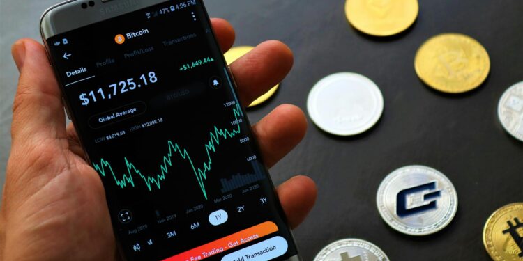 G. Love holds a smartphone showing a fake Ledger app with Bitcoin graphics in the background.