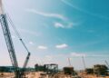 Construction site of a large data center with heavy machinery and cranes for expansion project.