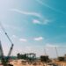 Construction site of a large data center with heavy machinery and cranes for expansion project.