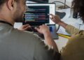 A diverse team collaborates at a computer, showcasing Dreamspace's no-code Web3 tool.
