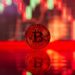 Bitcoin symbol with a downward trend line overlaid, oil barrels in background, reflecting market volatility.