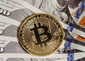 Stacks of U.S. dollar bills with Bitcoin and Tether logos, symbolizing crypto fraud and regulation.