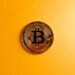 A tanker in the Strait of Hormuz with Bitcoin logos overlaying the scene, symbolizing crypto commerce.