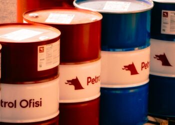 Oil barrels with rising price graphs, highlighting surging oil prices amid geopolitical tensions.