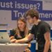 Cybersecurity professionals discussing OpenAI's new suite for partners in a tech conference setting.