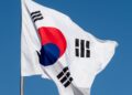 Digital representation of cryptocurrency with a North Korean flag and warning symbols.