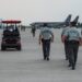 Li Xiong, chair of the Huione Group, escorted by officials at an airport for extradition to China.
