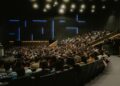 Large crowd at a cryptocurrency conference, with banners promoting Ripple's Swell 2026 event.