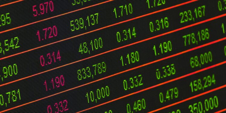 A stock market display board shows rising equity indices amid falling Brent crude oil prices.