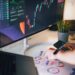 CEO sitting at a desk, surrounded by financial reports and cryptocurrency charts, looking contemplative.