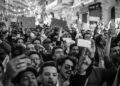 Protesters gather in a darkened street, holding phones and chanting amid Iran's internet blackout.
