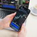 Trader analyzing crypto charts on a smartphone with a Telegram app interface displayed.