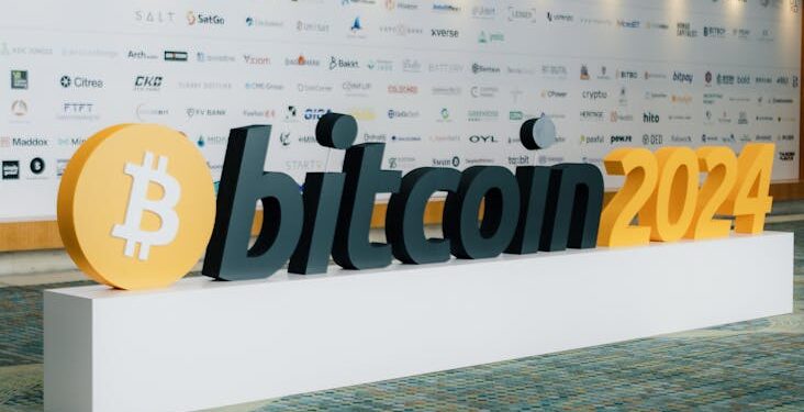 J. Christopher Giancarlo speaking at a finance conference with blockchain visuals in background.