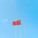 Chinese flags in front of AI technology graphics, symbolizing IP theft allegations.