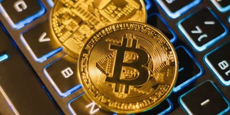 Golden Bitcoin coins stacked on a computer keyboard, symbolizing crypto finance and security.