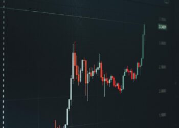 A digital display shows XRP price chart with upward trend and cryptocurrency graphics.