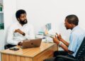 Two professionals discussing blockchain technology and AI in a modern office setting.