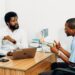 Two professionals discussing blockchain technology and AI in a modern office setting.