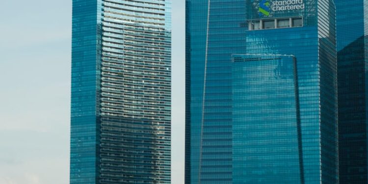 HSBC and Standard Chartered logos with a digital currency symbol and Hong Kong skyline.