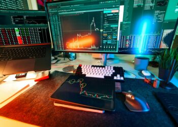 Investors analyzing Bitcoin trends at a financial conference, with charts and laptops.