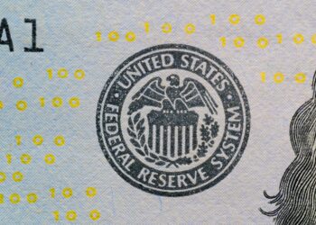 Jerome Powell speaking at a podium with Federal Reserve emblem, addressing financial regulations.