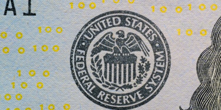 Jerome Powell speaking at a podium with Federal Reserve emblem, addressing financial regulations.