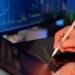 A financial analyst examines charts reflecting cryptocurrency market declines.