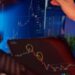A business professional reviews financial graphs on a laptop, featuring crypto and fiat integrations.