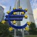 European Central Bank building with digital currency symbols superimposed.