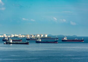 U.S. Navy ships positioned near Iranian ports as oil prices rise dramatically.