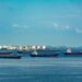 Oil tanker in port with Bitcoin symbol overlay, highlighting crypto use amid sanctions.