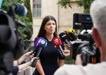Lori Chavez-DeRemer at a press conference, looking serious, surrounded by reporters.