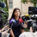 Lori Chavez-DeRemer at a press conference, looking serious, surrounded by reporters.