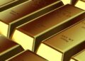 Gold bars stacked on a table, symbolizing falling gold prices amid economic uncertainty.