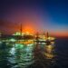 Oil rigs at sea with rising graphs, reflecting market volatility due to naval tensions.
