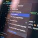 Developers discussing generative AI tools with a "banned" sign in a gaming studio setting.