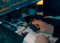 A financial analyst reviewing cryptocurrency and AI investment charts on a computer screen.