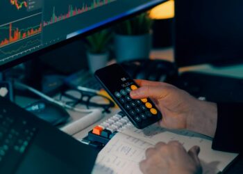 A financial professional reviewing cryptocurrency regulations with stablecoin graphics on a screen.