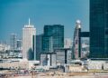 A Dubai skyline with financial district buildings and blockchain symbols overlaying the scene.