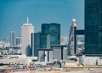 A Dubai skyline with financial district buildings and blockchain symbols overlaying the scene.