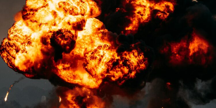 Flames erupt from a damaged oil pipeline, with smoke rising against a darkened sky.