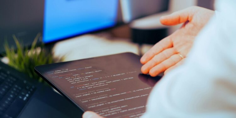 A developer uses a no-code AI app builder on a laptop in a modern workspace.