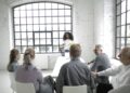 Group of diverse finance leaders discussing blockchain technology in a conference room.