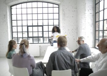 Group of diverse finance leaders discussing blockchain technology in a conference room.