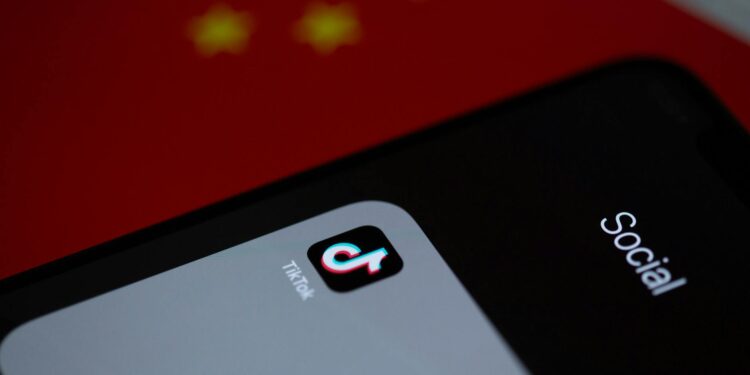 Graphic showing a smartphone with the Bitchat app logo and a backdrop of China's flag.